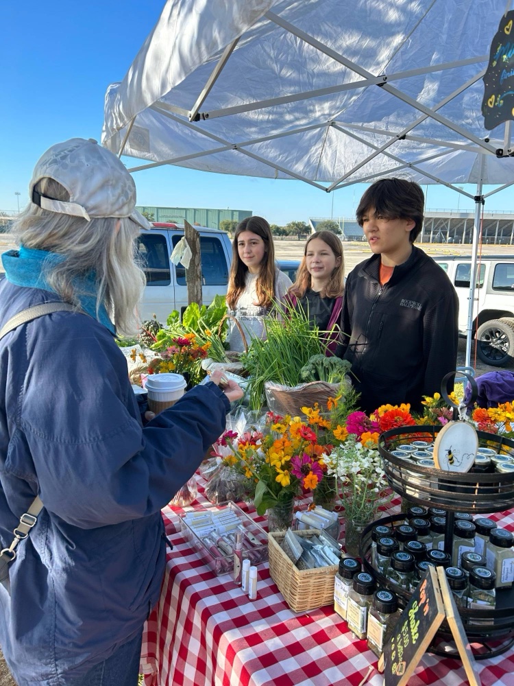 Adolescents selling their produce at a farmers market